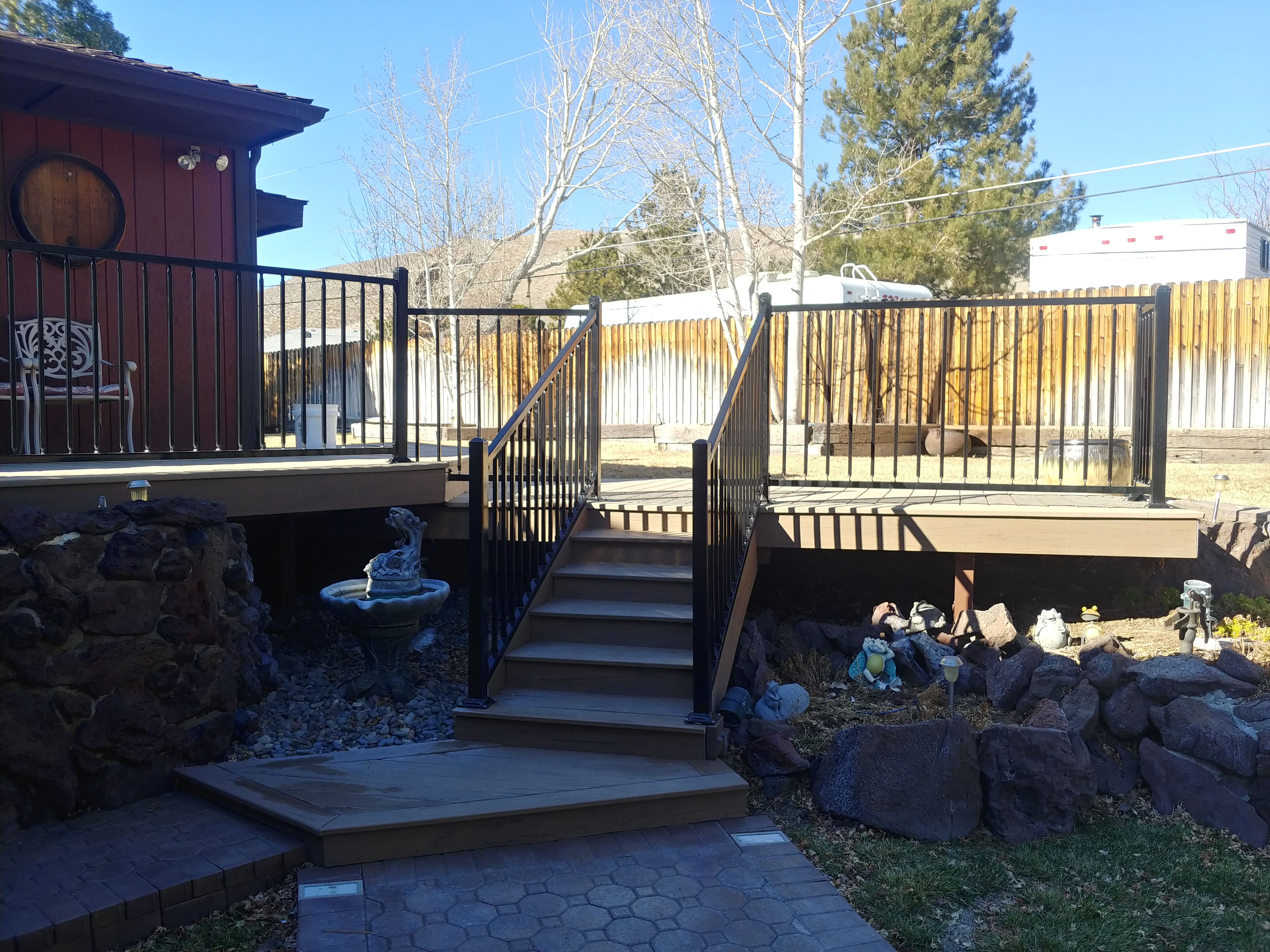 picture of black outdoor railing surrounding a backyard deck